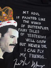 Hand-painted profile portrait of Freddie Mercury wearing a crown on black T-shirt with blue butterfly and poetic phrase.
