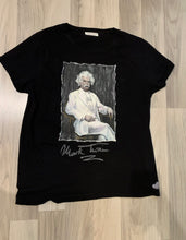 Full view of hand-painted Mark Twain T-shirt on wooden floor – artistic wearable portrait