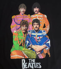 Close-up of the Beatles’ hand-painted  on a t-shirt, showing vivid color and detailed brushwork in their Sgt. Pepper uniforms.