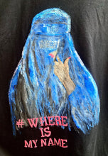 Close-up of the #whereismyname hashtag painted below the portrait on the t-shirt, emphasizing the message of women’s rights.
