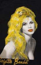 Hand-painted portrait of Brigitte Bardot’s face and décolleté on black T-shirt, with golden hair and daisies.