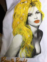 Close-up of Brigitte Bardot portrait with flowing blond hair and daisies, painted in relief on white T-shirt.
