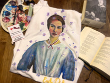 emily dickinson with iolets painted portrait on tshirt on table near poems book and brushes