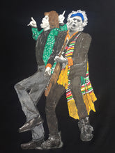 Close-up view of hand-painted details on a Mick Jagger and Keith Richards t-shirt, highlighting vibrant colors and textured brushstrokes.