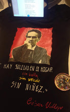 Artist painting César Vallejo portrait and quote on black T-shirt using permanent relief colors
