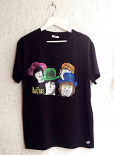 Full view of a hand-painted t-shirt featuring vibrant, colorful portraits of The Beatles’ faces in expressive pop art style.