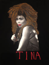 Artistic hand-painted close-up of Tina Turner’s face on a black t-shirt, showcasing fine brush details and vivid design.