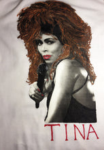 hand-painted close-up of Tina Turner’s face on a white t-shirt, showcasing fine brush details and vivid design.