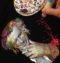 Artist’s hand painting Keith Richards on black T-shirt – vibrant color work in progress